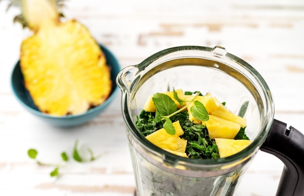 Vue de dessus du mélangeur avec des morceaux d&#39;ananas et d&#39;épinards