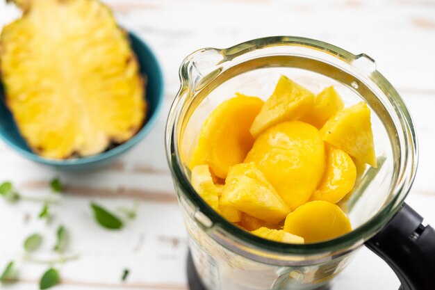 Vue de dessus du mélangeur avec des morceaux de mangue et d&#39;ananas