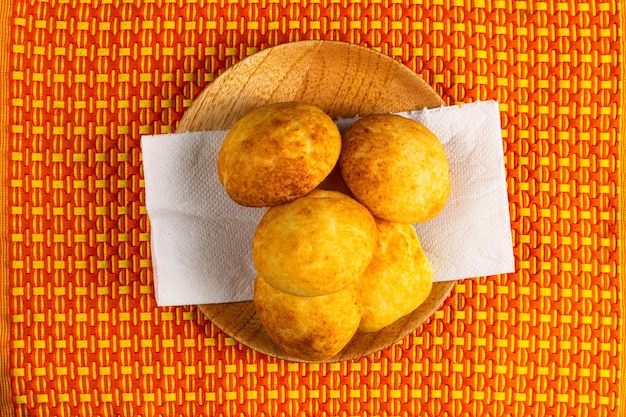 Vue de dessus du pain au fromage colombien almojabanas colombien typique sur une plaque de bois avec serviette