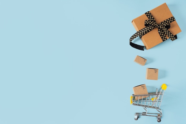 Photo vue de dessus du panier de jouets avec des boîtes et des cadeaux sur fond bleu, copiez l'espace pour le texte ou la conception