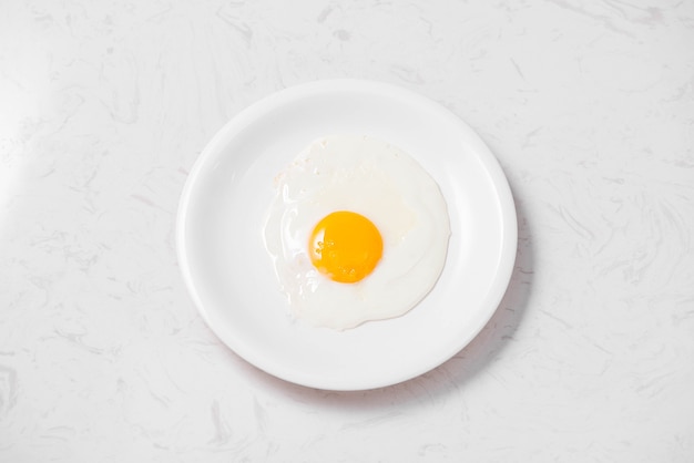 Vue de dessus du petit-déjeuner rapide et sain traditionnel composé d'œufs au plat servis dans une assiette.