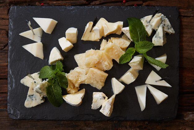 Vue de dessus du plateau de fromages sur fond de plaque de pierre noire