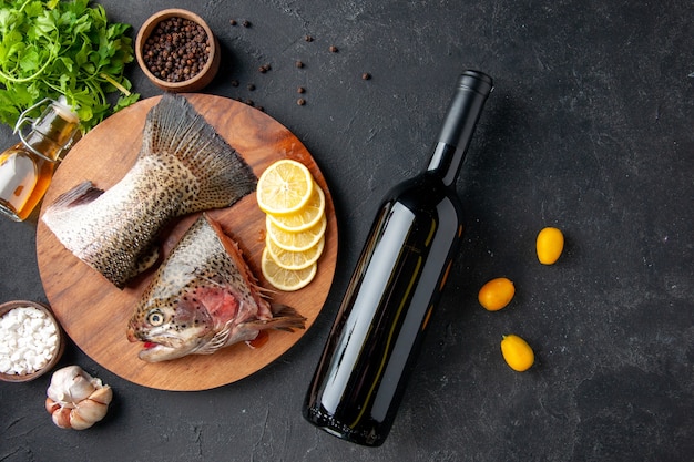 vue de dessus du poisson frais tranché avec des tranches de citron et du vin sur fond sombre repas de fruits de mer océan nourriture repas salade eau poisson mer viande