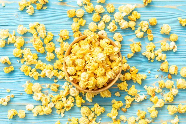 Vue de dessus du pop-corn jaune sur des planches de bois bleu