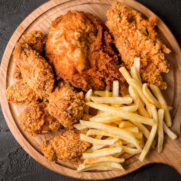 Vue de dessus du poulet frit avec des frites sur une planche à découper