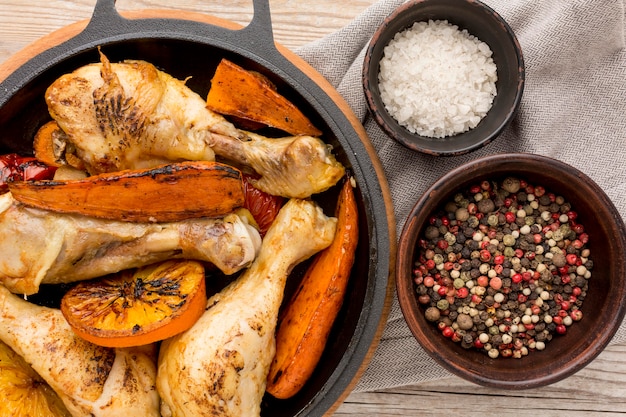 Vue de dessus du poulet et des légumes cuits au four dans une casserole avec des condiments