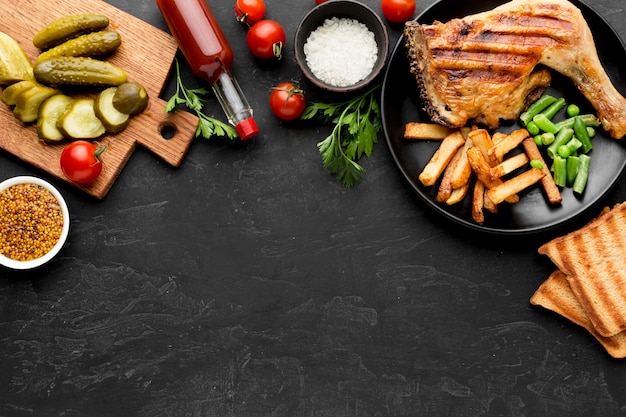 Photo vue de dessus du poulet et des pommes de terre cuits au four sur plaque avec cornichons et copy-space