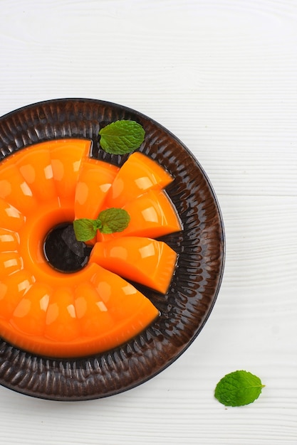 Vue de dessus du pudding à la mangue et à l'orange en tranches sur une plaque noire, pour le petit-déjeuner ou le Tajil Ramadan. Copiez l'espace pour le texte ou la recette