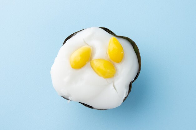 Vue de dessus du pudding thaïlandais à la crème de noix de coco et du dessus avec des graines de Ginkgo biloba, dessert traditionnel thaïlandais, isolé sur fond bleu.