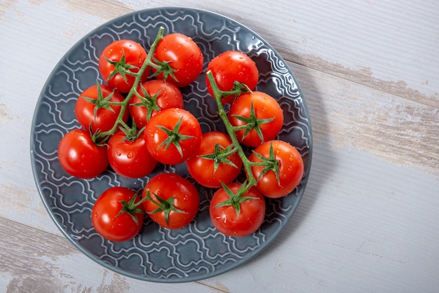 Vue de dessus du raisin de tomates cerises sur la plaque bleue