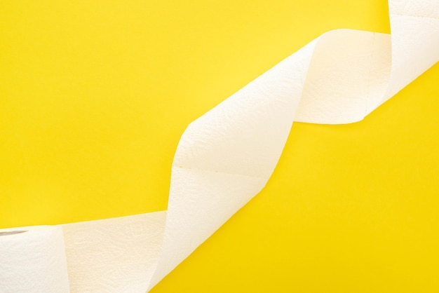 Vue de dessus du rouleau de papier toilette blanc sur fond jaune