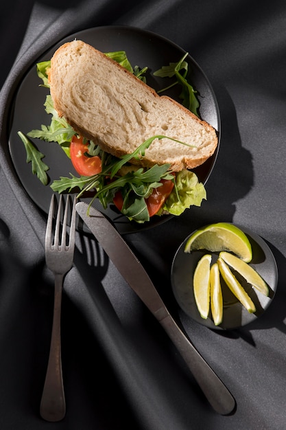 Photo vue de dessus du sandwich toast avec tomates, verts et limes