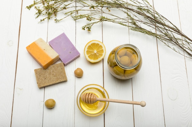 Vue de dessus du savon fait main avec des olives au citron et du miel sur une table en bois