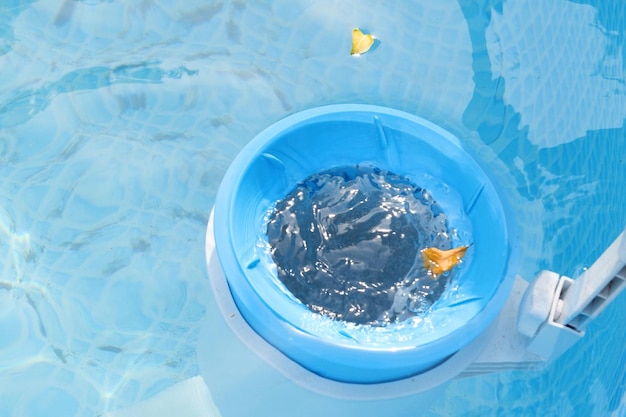 Photo vue de dessus du skimmer bleu pour le nettoyage de la piscine en eau claire concept de nettoyage de piscine contaminée