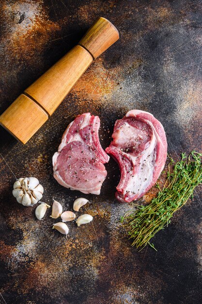 Photo vue de dessus du steak de côtelette de porc biologique cru avec des ingrédients