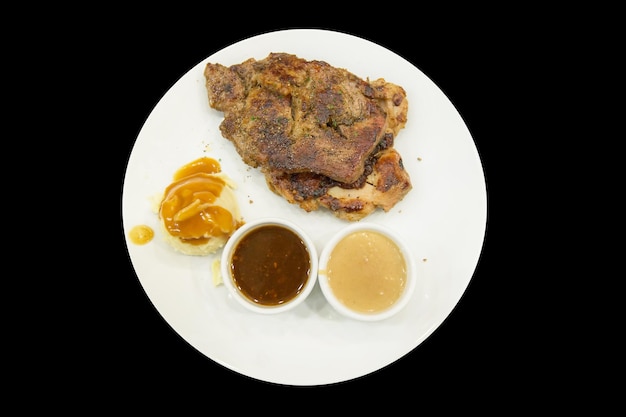Vue de dessus du steak de poulet au poivre noir sur une assiette blanche focus sélectif