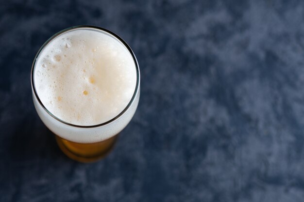 Photo vue de dessus du verre à bière avec bouchon en mousse et fond