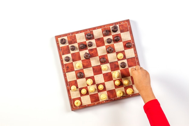 Vue de dessus de l'enfant remet un échiquier jouant aux échecs