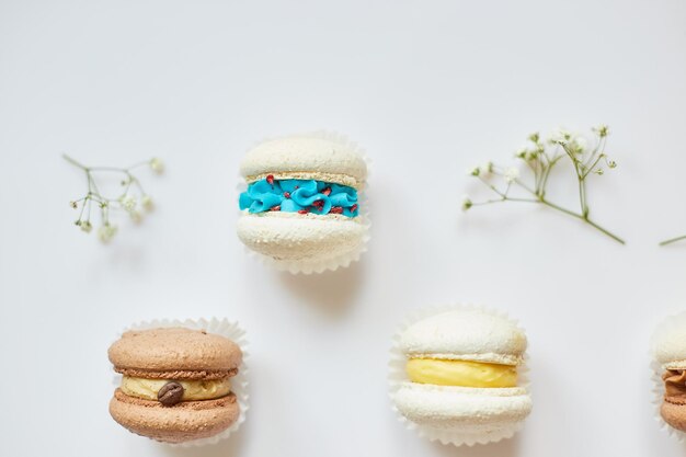 Vue de dessus ensemble de différents biscuits français macarons gâteau macarons avec des fleurs