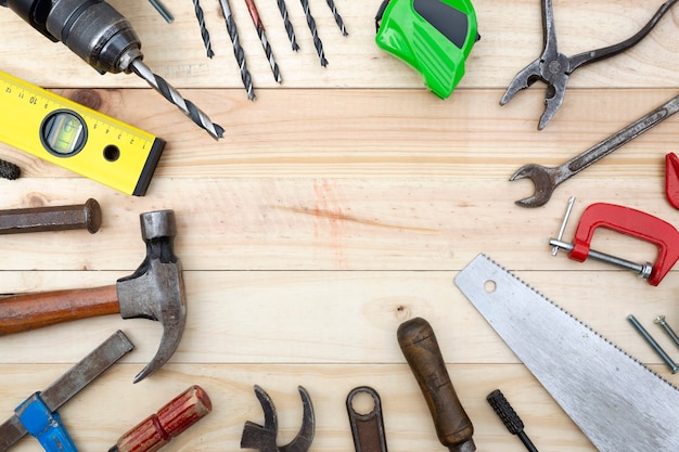 Vue de dessus ensemble d'outils et accessoires d'ébénisterie placés sur une planche de bois de pin naturel avec espace de copie