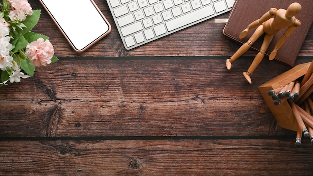 Vue de dessus de l'espace de travail de concepteur créatif avec une tasse de café pour ordinateur portable et des fleurs sur un bureau en bois