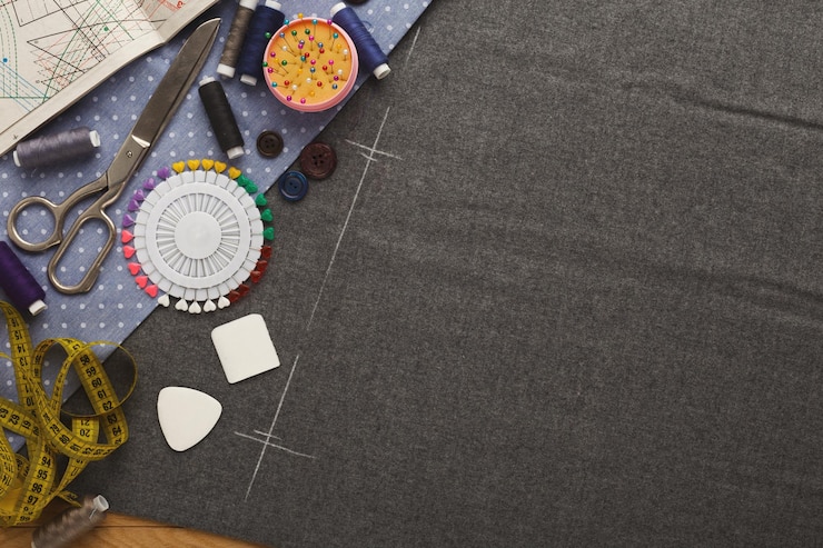 Photo vue de dessus de l'espace de travail du créateur de mode. matériel de couture, règle, morceaux de craie, épingles et ciseaux sur des carrés de tissu avec espace de copie