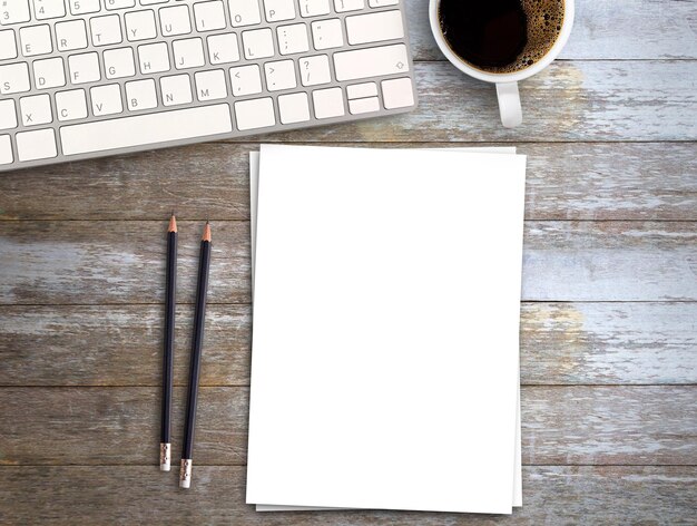 Vue de dessus Espace de travail Minmal avec clavier papier blanc et tasse à café sur fond de table en bois