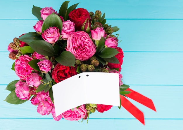 Vue de dessus d'une étiquette cadeau vierge avec espace de copie d'un élégant bouquet de roses roses et rouges. Concept de la Saint-Valentin et anniversaire