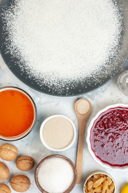 vue de dessus farine blanche autour des oeufs graines noix et gelée sur un bureau blanc tarte gâteau confiture oeuf cuire couleur des fruits pâte alimentaire