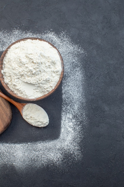 vue de dessus farine blanche avec petits petits pains crus sur fond sombre pâte à tarte four gâteau biscuit cuisson cuisson