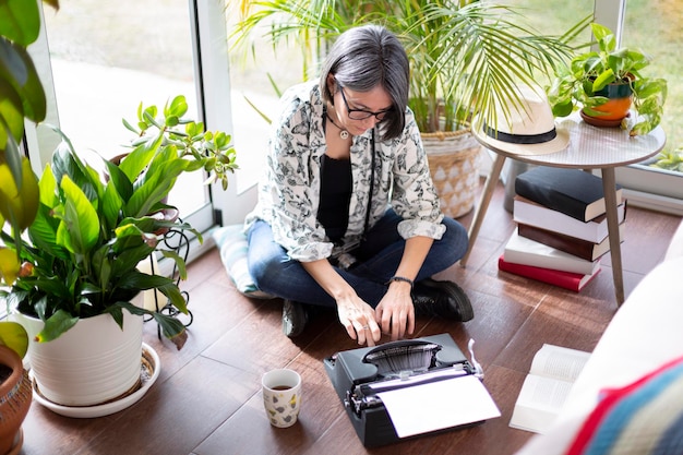 Vue de dessus d'une femme adulte tapant sur une machine à écrire Concept de travail à domicile