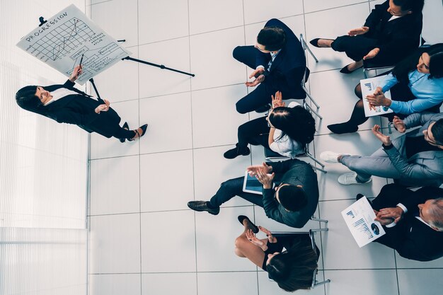 Vue de dessus. femme d & # 39; affaires pose des questions lors d & # 39; une présentation commerciale