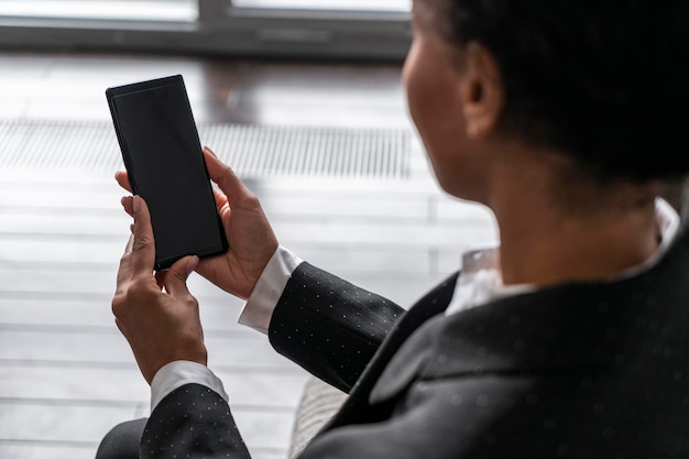 Vue de dessus d'une femme africaine avec téléphone dans un fauteuil