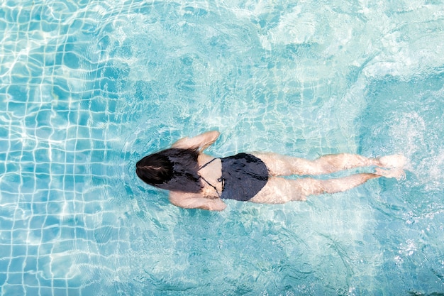 Vue de dessus d&#39;une femme asiatique nageant dans la piscine.