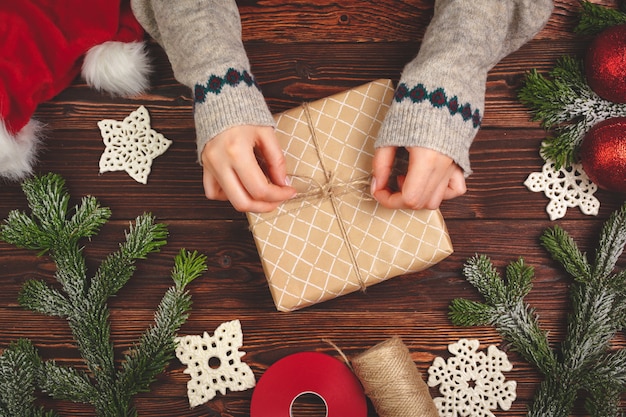 Vue de dessus d'une femme avec un cadeau de Noël sur fond en bois