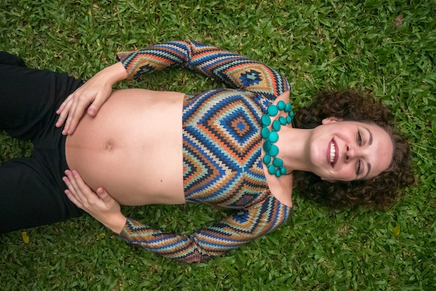 Vue De Dessus De La Femme Enceinte Portant Dans L'herbe.