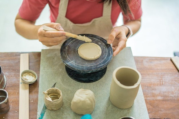 Vue de dessus Femme potier travaillant sur une roue de potier fabriquant un pot en céramique à partir d'argile dans un atelier de poterie