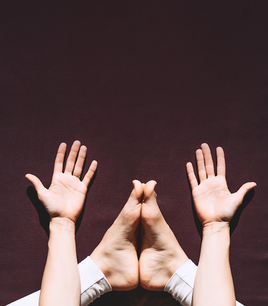 Vue de dessus d'une femme pratiquant le yoga Gros plan des pieds et des paumes des femmes sur un tapis de yoga avec espace de copie