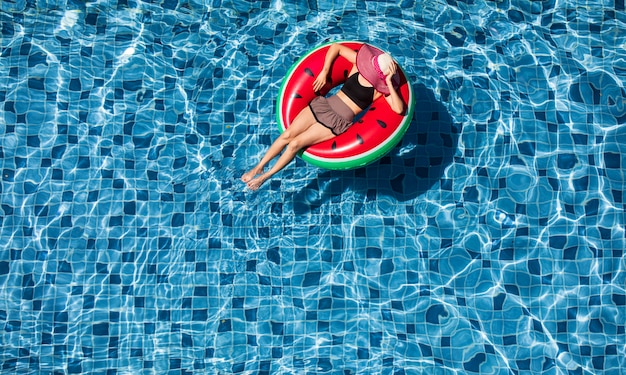 Vue de dessus de la femme s'étendent sur le ballon au fond de la piscine