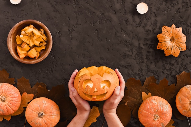 Vue de dessus d'une femme sculpte le visage d'un jack-o'-lantern