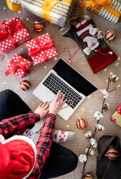 Vue de dessus de femme shopping en ligne aux vacances de Noël tenant la boîte-cadeau