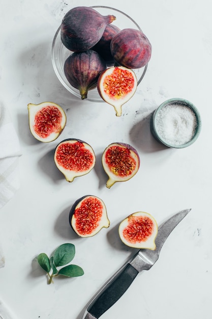 Vue de dessus des figues tranchées et couteau sur fond blanc