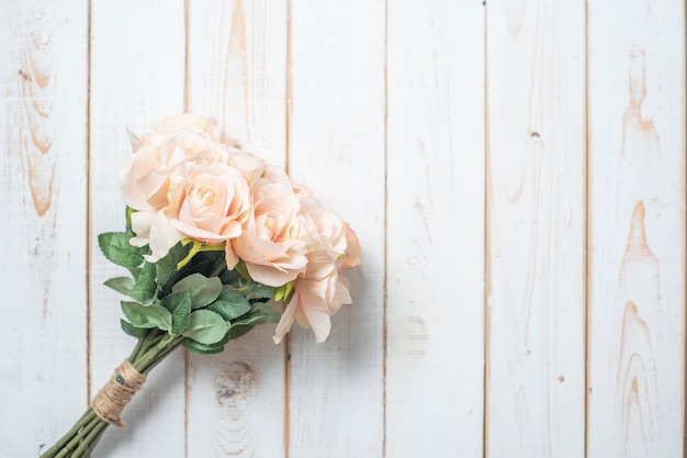 Vue de dessus des fleurs de mariage sur fond de bois blanc