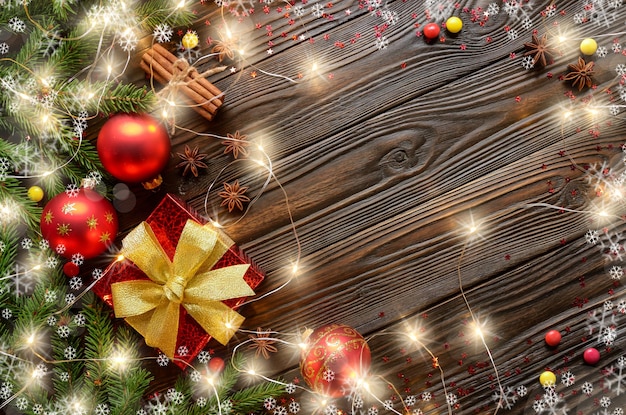 Vue de dessus sur fond de boule de Noël avec boîte-cadeau rouge boules de verre guirlande lumineuse et brindilles de sapin