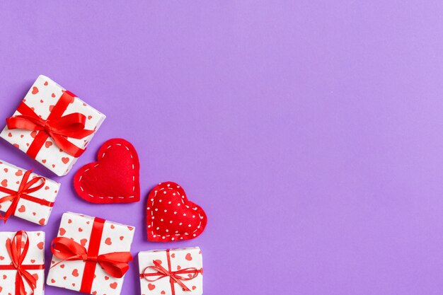 Vue de dessus fond de valentine coloré fait de coffrets cadeaux et de coeurs en textile rouge. Concept de la Saint-Valentin avec espace copie