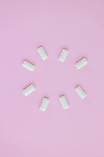 Vue de dessus de la forme ronde des chewing-gums blancs sur fond rose