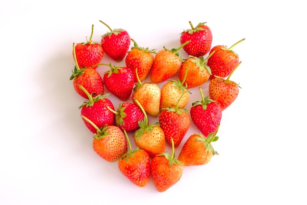Photo vue de dessus fraises à l'arc sur une surface blanche. belle fraise rouge