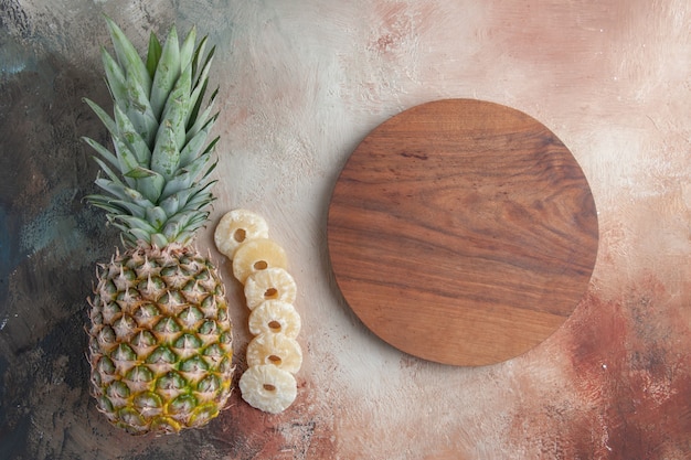 Vue de dessus des fruits d'ananas fixant des anneaux d'ananas secs sur une table en bois