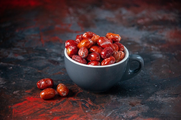 Vue de dessus des fruits frais crus à l'intérieur et à l'extérieur d'une tasse grise sur fond de couleurs mélangées avec espace libre