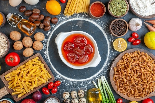 Vue de dessus gelée fruitée autour des oeufs légumes pâtes noix et assaisonnements sur fond sombre photo couleur repas régime alimentaire cru